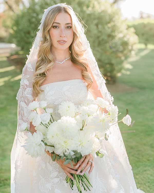 Sposa elegante con bouquet di fiori bianchi