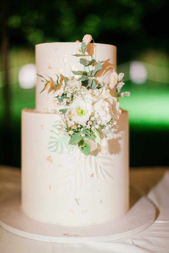 Torta nuziale bianca decorata con fiori freschi