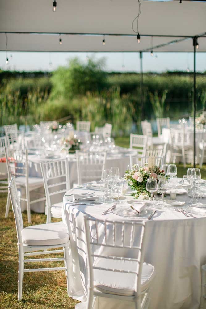 Tavoli allestiti per matrimonio all'aperto.
