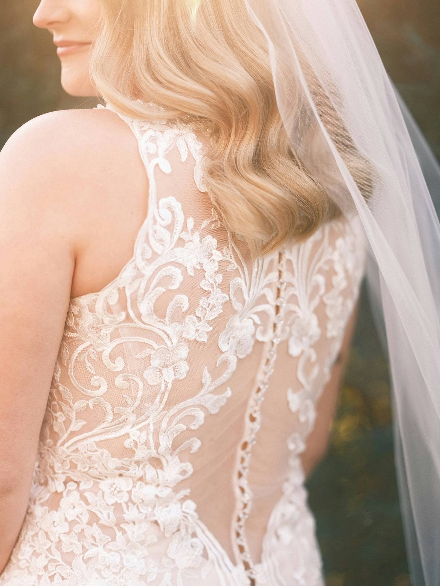 Dettaglio di un abito da sposa in pizzo bianco.